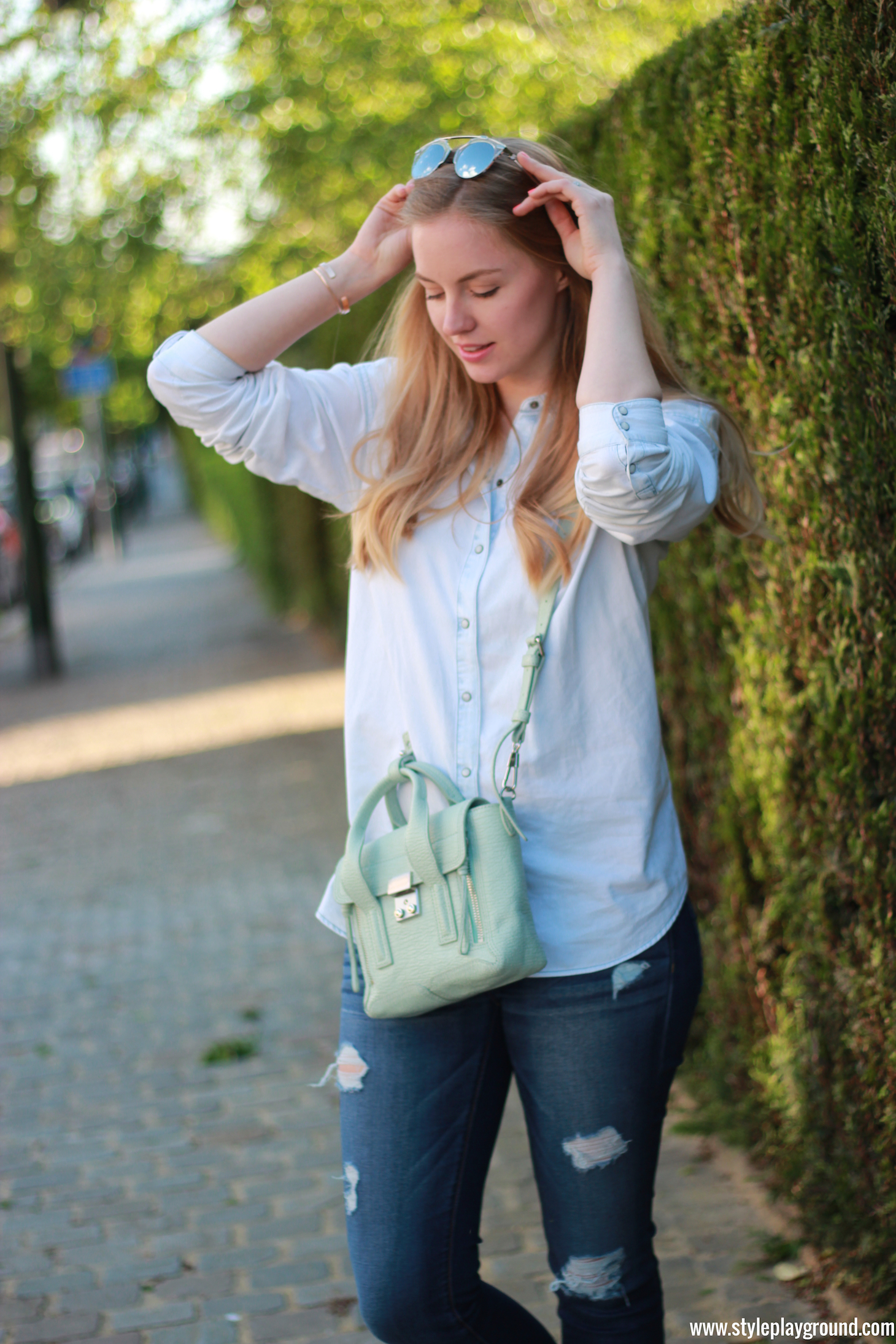 Axelle Blanpain of Style playground is wearing a Zara denim shirt, American Eagle ripped jeans, white Converse, Phillip Lim bag, Tiffany T bracelet and Cartier love bracelet