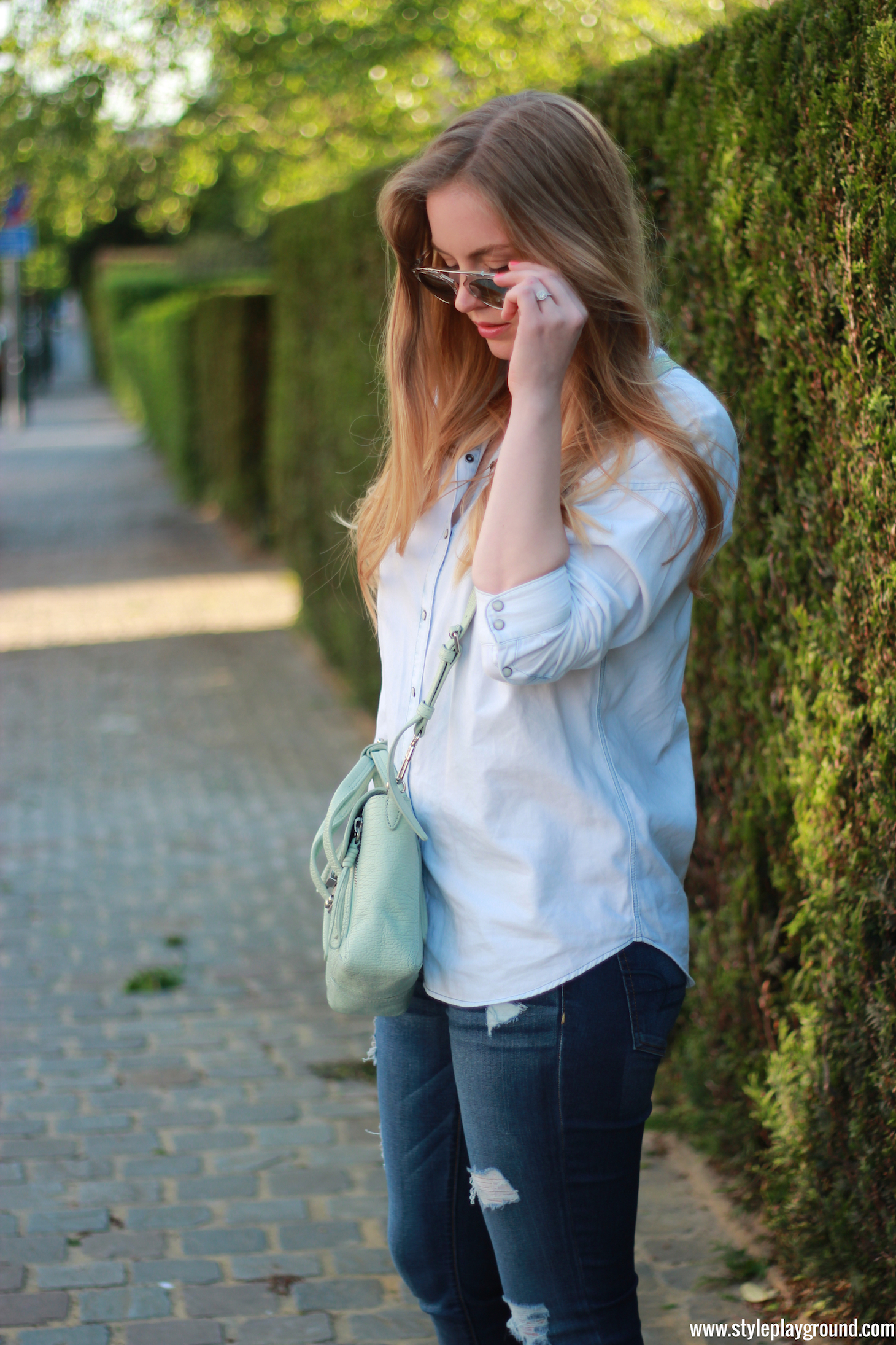 Axelle Blanpain of Style playground is wearing a Zara denim shirt, American Eagle ripped jeans, white Converse, Phillip Lim bag, Tiffany T bracelet and Cartier love bracelet