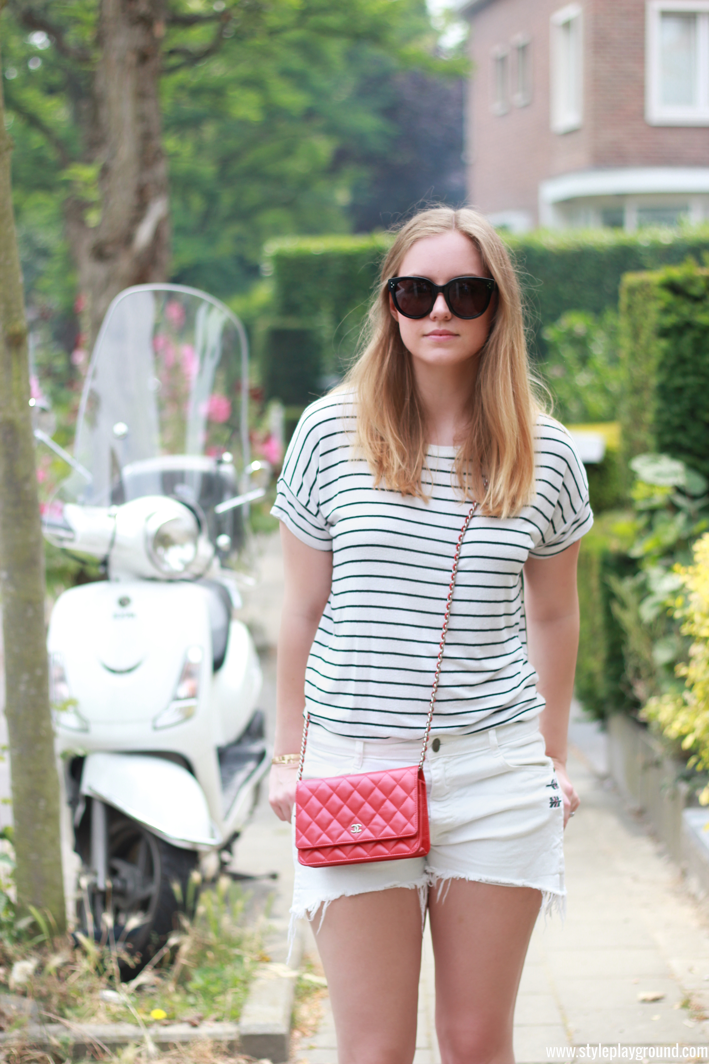 Axelle Blanpain from Style playground is wearing Zara shorts & t-shirt, white Converse sneakers, Chanel red WOC, Celine Audrey sunglasses